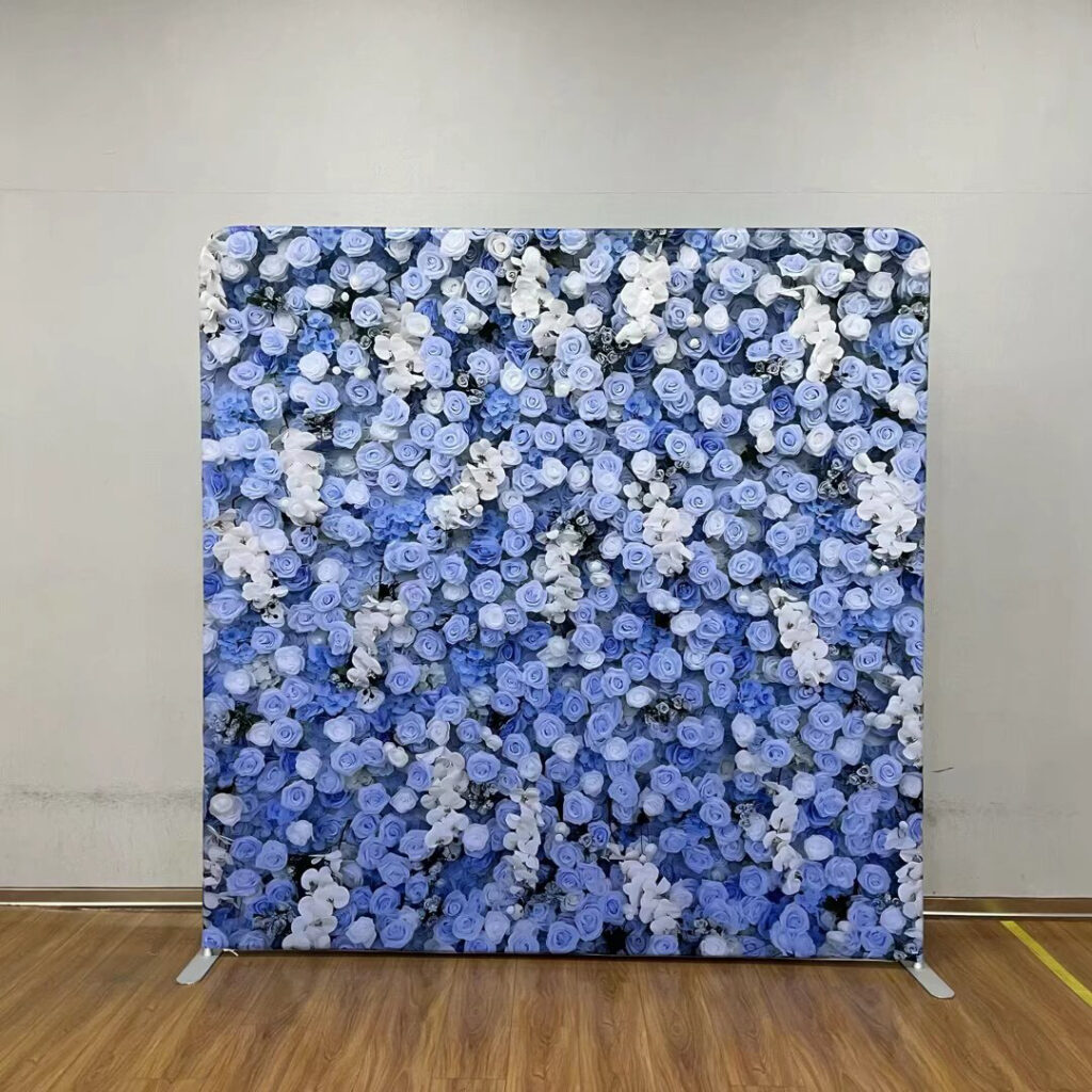 A portable event backdrop featuring a dense arrangement of blue and white roses; contact us to book this floral background for your next party.